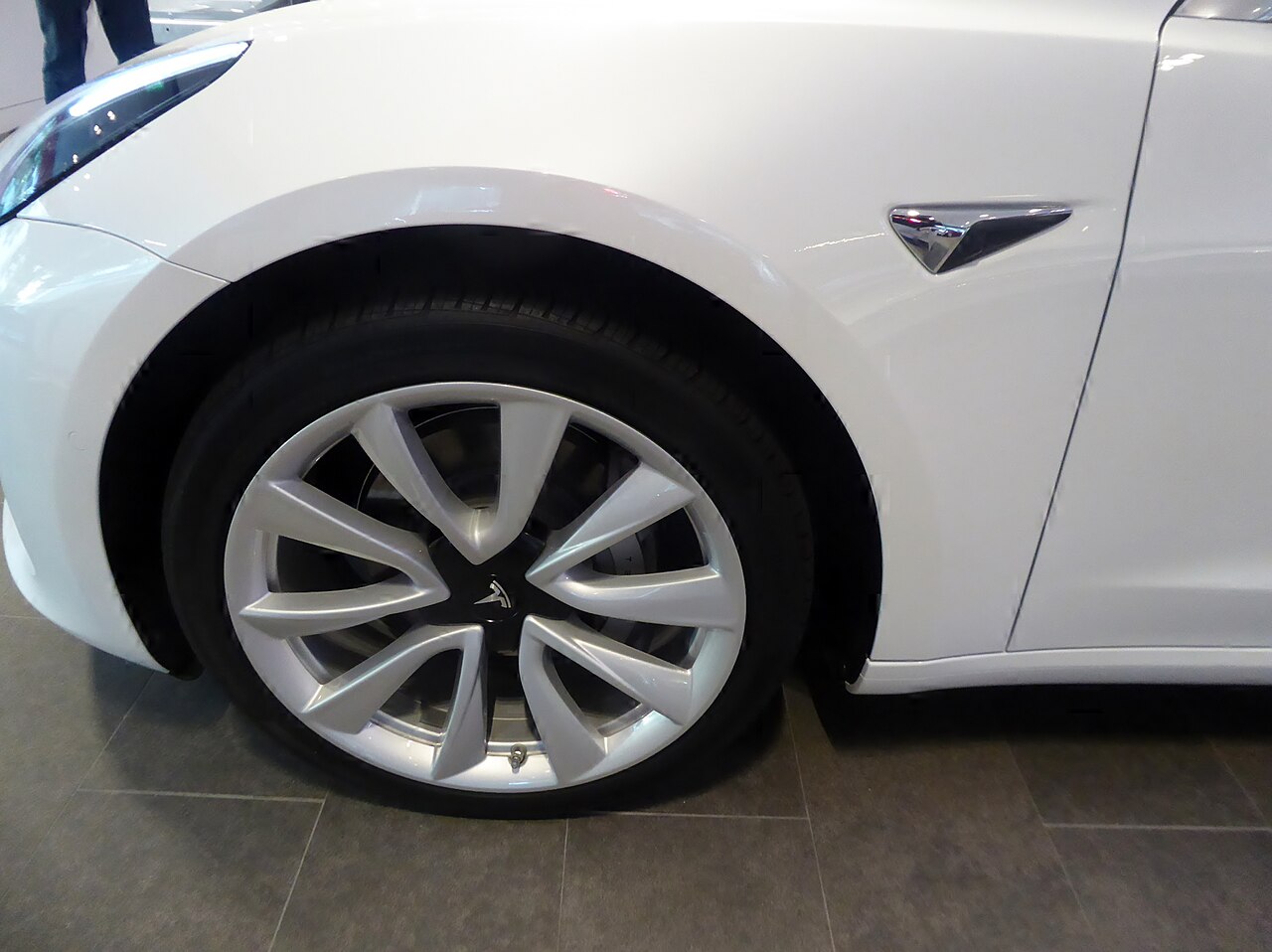 Beyaz Tesla Model 3 elektrikli otomobilin ön lastiği ve jantının yakından görünümü