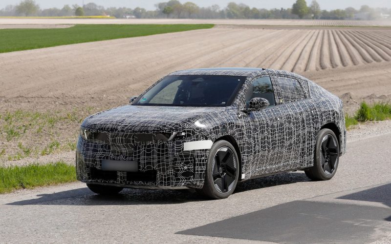Tamamen elektrikli BMW iX4 SUV coupe prototipi, 2026 test sürüşünde siyah-beyaz kamuflajla çekilmiş araç fotoğrafı