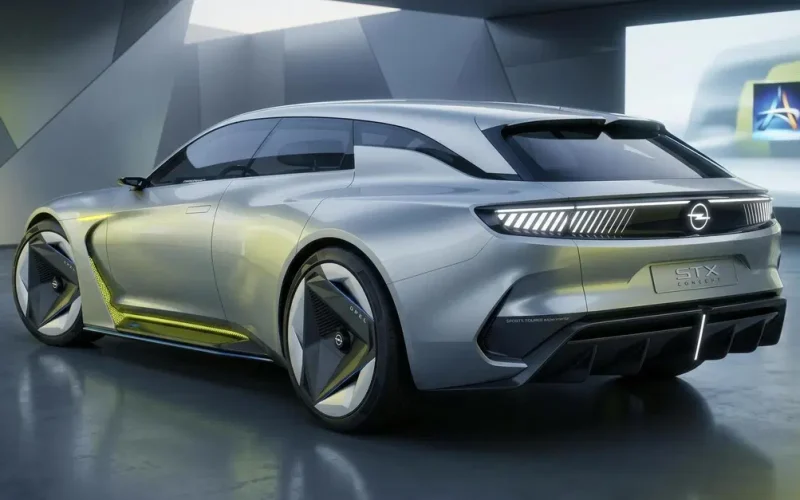 Paris 2026 Otomobil Fuarı'nda sergilenen gümüş Opel STX Concept elektrikli station wagon prototipinin arkadan görünümü; STX Concept yazısı ve aydınlatmalı Opel amblemi